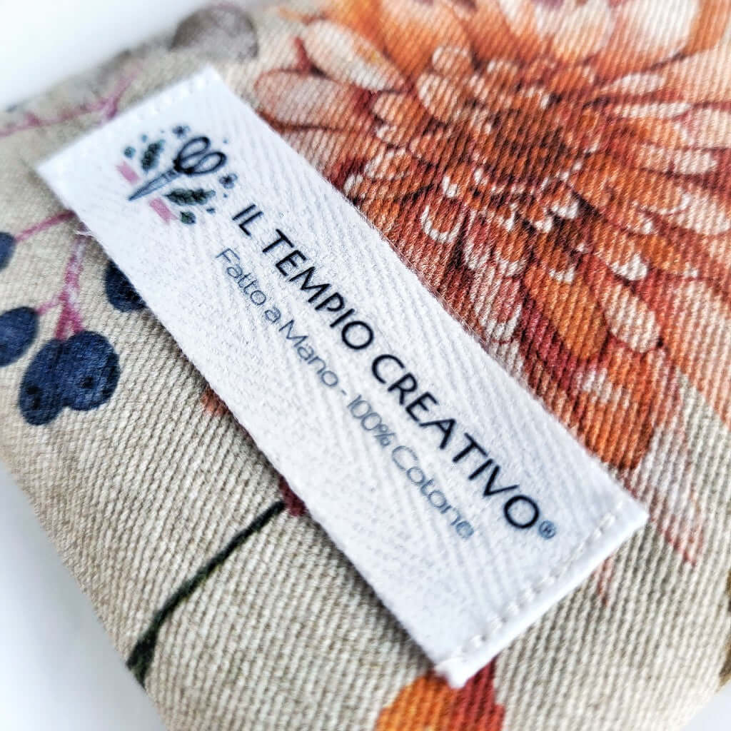 Dettaglio Etichetta. Cuscino rilassante per occhi eye pillow realizzato in cotono 100%, sfoderabile e lavabile, con ingredienti naturali antinfiammatori, rigeneranti e rilassanti. Stoffa Autunnale con camomilla.