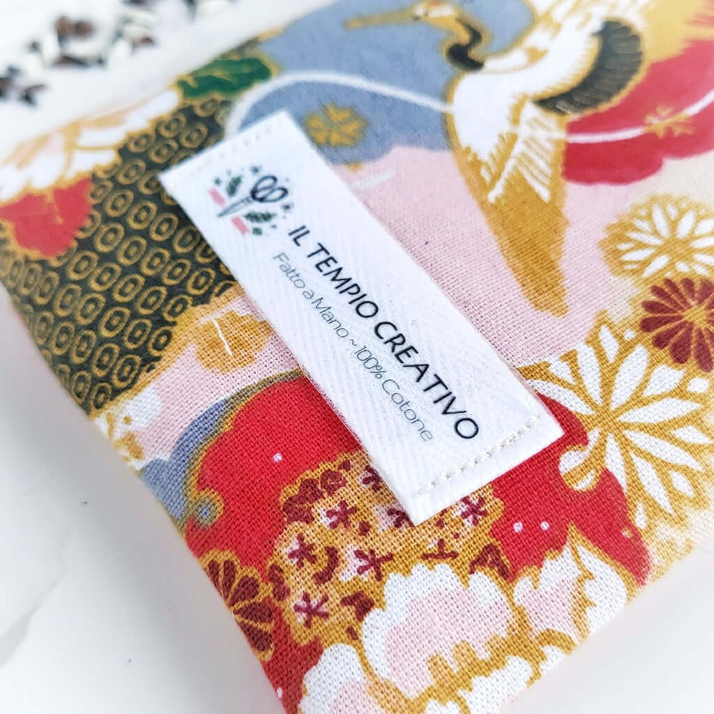 Etichetta del Cuscino rilassante per occhi (eye pillow) realizzato in puro cotone, sfoderabile e lavabile. All'interno materie prime naturali antinfiammatorie e rigeneranti per lo sguardo, borse e occhiaie. Tea Nero Albicocca e stoffa giapponese ikebana.