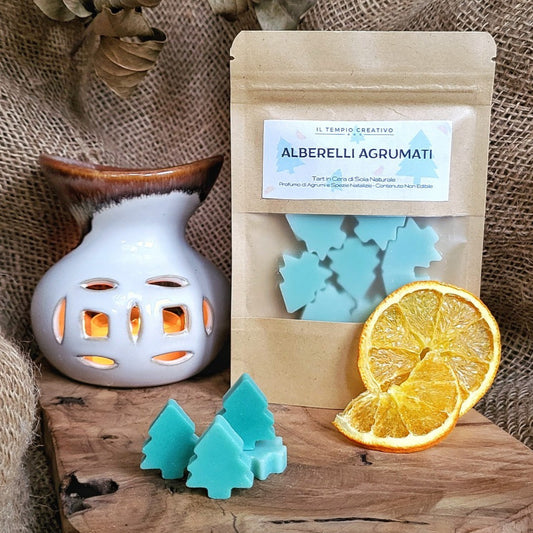 Tart profumate o wax melts in cera di soia a forma di Albero di Natale al profumo di Agrumi. Presente anche il Bruciatore in Ceramica con lumino acceso.