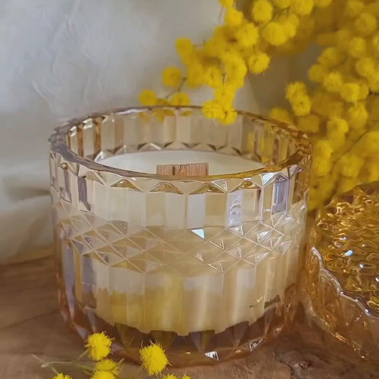 Video della candela in cera di soia con stoppino in legno al profumo di mimosa, realizzata in portagioie di vetro lavorato con coperchio decorato, per celebrare l'8 marzo la Festa della Donna.